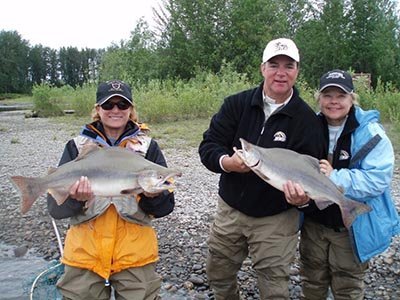 Couples posing with beautiful wild pink salmon on a remote fly-in fishing trip.