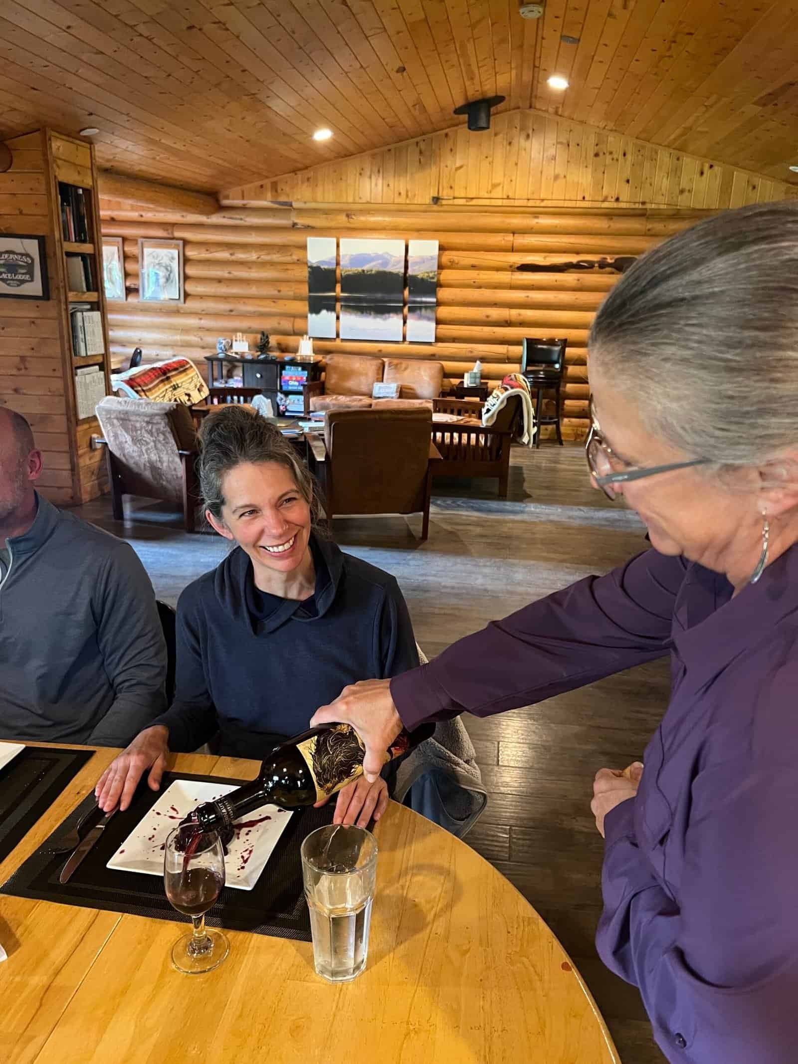 Service with a smile with complimentary wine at Wilderness Place Lodge, remote Alaska.